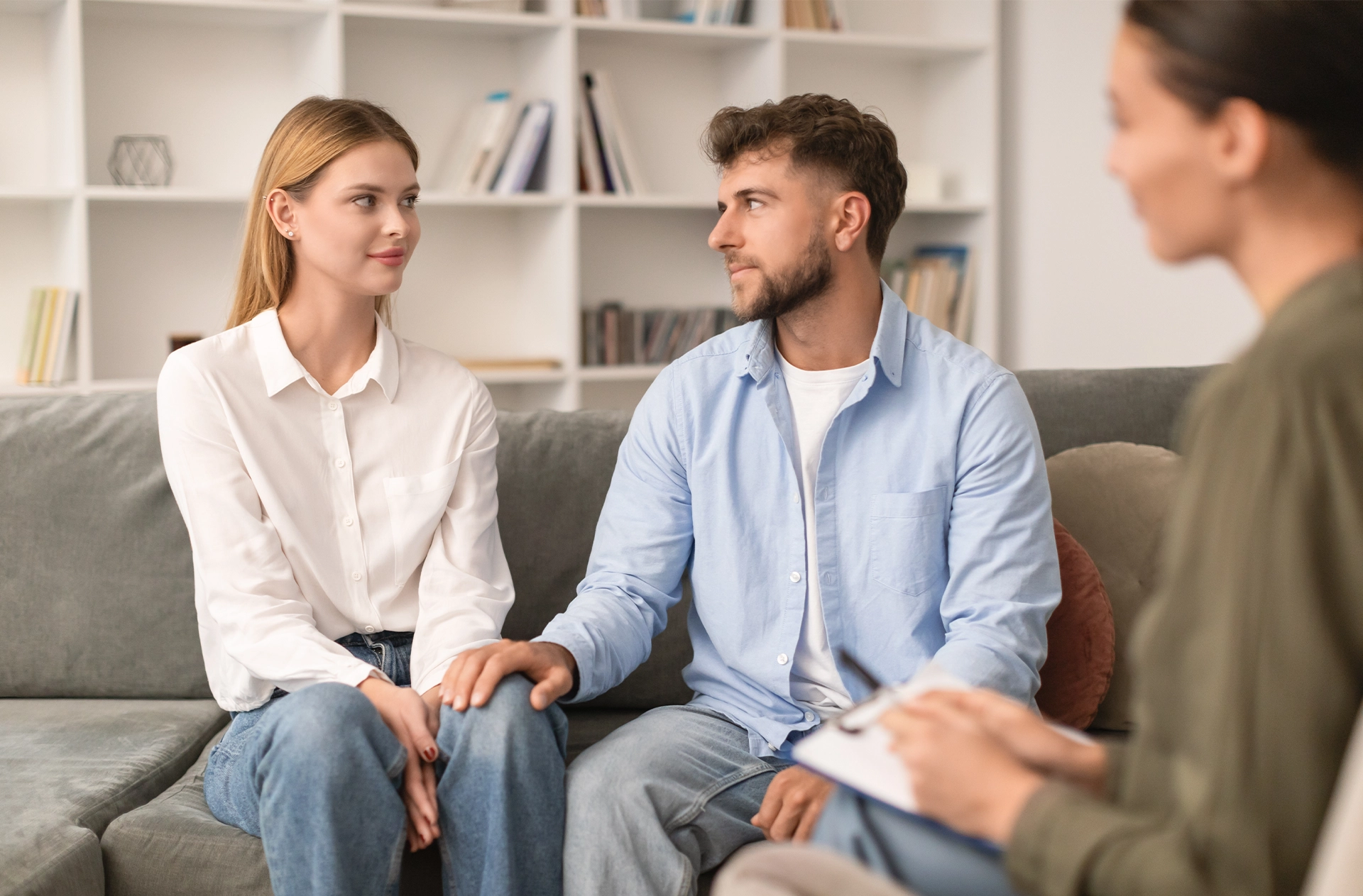 A young couple sitting together on a sofa during a couples consultation